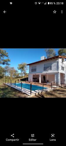 Un edificio con piscina enfrente. en Casa Blanca, en Villa Rumipal