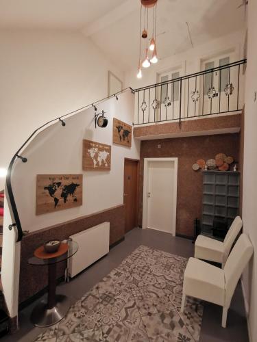 a living room with a staircase and a chair at Pension Föhrenhain in Gerasdorf bei Wien