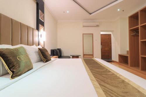 a bedroom with a large white bed in a room at Coins Hotel Jakarta in Jakarta
