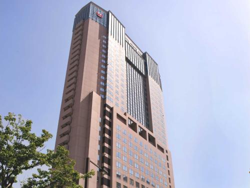 金沢市にあるホテル日航金沢の背景の青空の高い建物