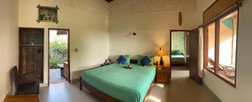 a bedroom with a green bed in a room at 1000 Dream Bungalow in Lovina