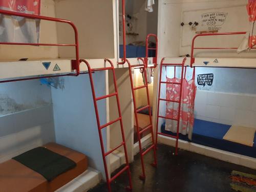 a room with two bunk beds and a ladder at Syalala bnb in Timuran