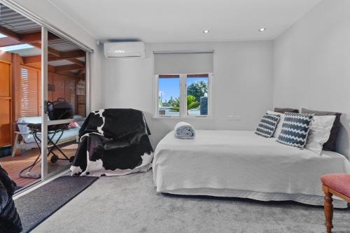 ein Schlafzimmer mit einem Bett und einem Schreibtisch. in der Unterkunft Bach on Wilson - Waihi Beach Holiday Home in Waihi Beach
