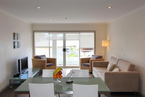 a living room with a couch and a table at Crow's Nest Apartments in Whitianga