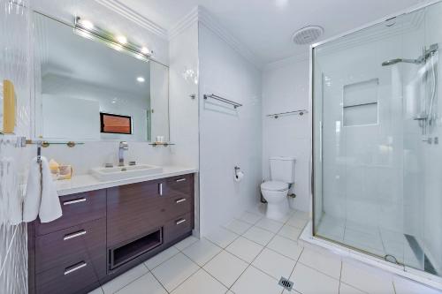 a bathroom with a shower and a sink and a toilet at Hilltop Views - Cannonvale in Airlie Beach