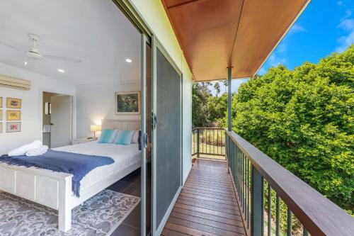 a bedroom with a bed on a balcony at Hilltop Views - Cannonvale in Airlie Beach