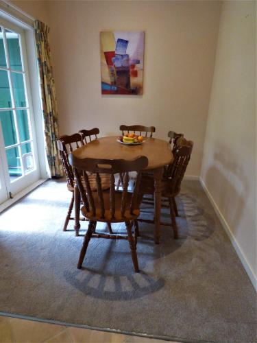 a dining room with a wooden table and chairs at Sahara Deluxe Studios in Dunedin