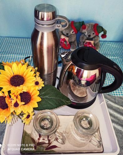 a tray with a coffee pot and sunflowers on it at Bdr Bukit Tinggi Klang Tropicana Garden Homestay in Klang