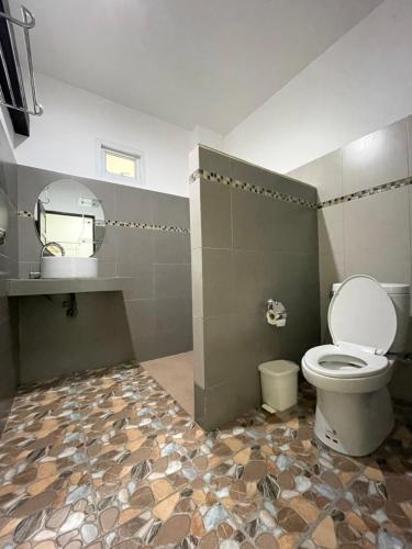 a bathroom with a toilet and a tiled floor at Khaosok Good view Resort - SHA PLUS in Khao Sok National Park
