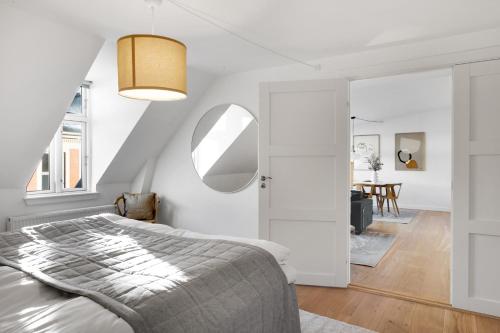 een slaapkamer met een bed en een spiegel bij Sanders Leaves - Precious Two-Bedroom Penthouse In Downtown Copenhagen in Kopenhagen