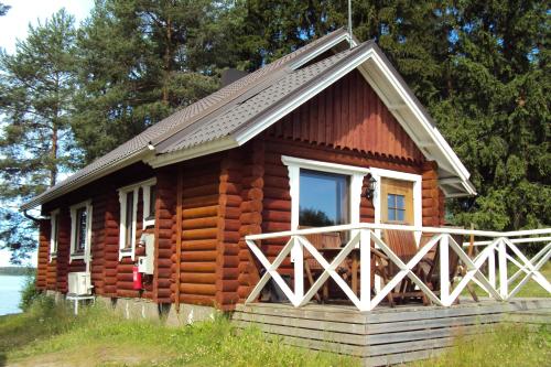 a log cabin with a porch and a window at Kaijansaaren Lomamökit in Tölvä