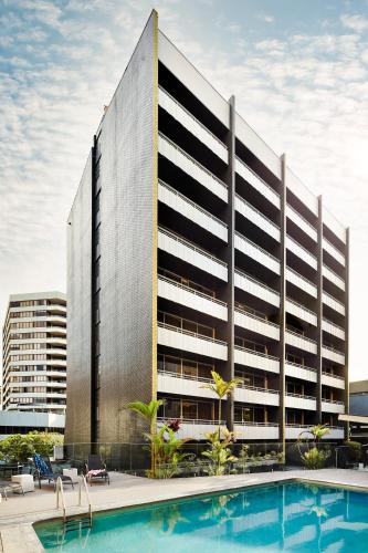 a large building with a swimming pool in front of it at Punthill Spring Hill in Brisbane