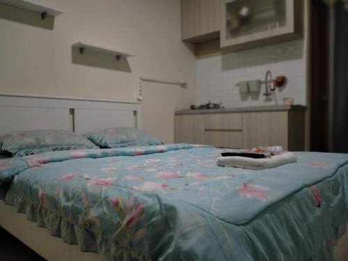 ein Bett mit einer blauen Decke mit Fisch drauf in der Unterkunft Cinere Resort Apartment by Celebrity Room in Tjinere-wetan