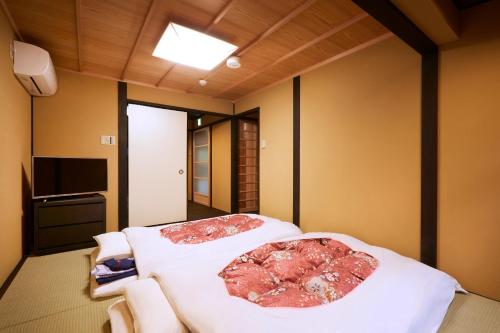 um quarto com duas camas e uma televisão em Rinn Kujoharikoji 59 em Quioto