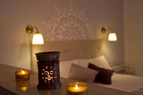 two candles on a table next to a bed at Ecolodge Selvitelle - Sustainable Retreat Amidst Olive Groves in Cilento in Cicerale