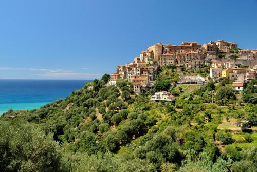 a town on a hill next to the ocean at Ecolodge Selvitelle - Sustainable Retreat Amidst Olive Groves in Cilento in Cicerale