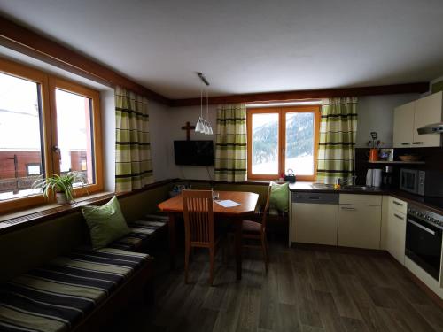 eine Küche mit einem Tisch und einem Esszimmer in der Unterkunft Haus Gamssprung in Steinberg am Rofan