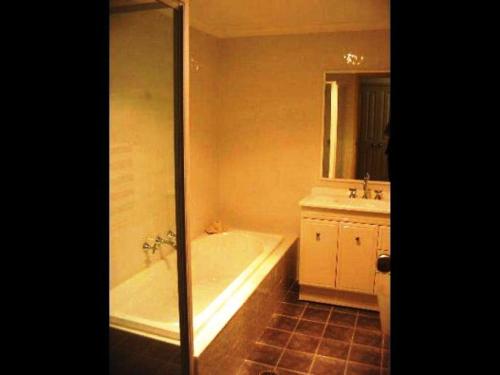 ein Badezimmer mit einer Badewanne und einem Waschbecken in der Unterkunft Sandy Place on Long Beach in Long Beach