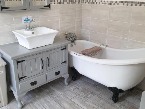 a bathroom with a sink and a bath tub and a sink at Breede River View with mooring at Witsand,Self-Catering Apartment in Witsand