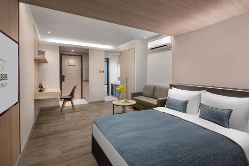 um quarto de hotel com uma cama e uma sala de estar em Modena by Fraser Hong Kong em Hong Kong