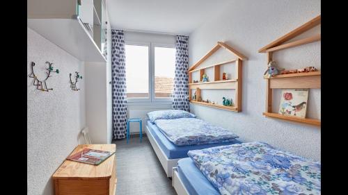 um pequeno quarto com 2 camas e uma mesa em Elfe-apartments cozy apartment with lake view for 6-7 guests em Emmetten