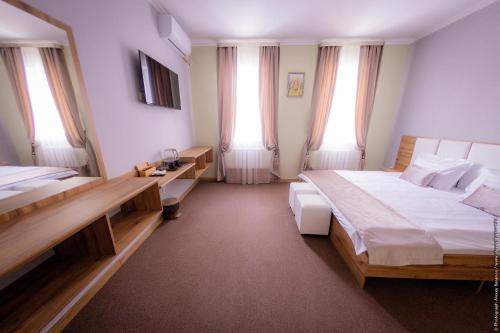 a bedroom with two beds and two windows at AS Inn Hotel in Karagandy