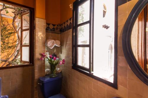 a bathroom with a blue toilet and two windows at Garlands Del Rio Riverside Boutique Hotel in Puerto Vallarta