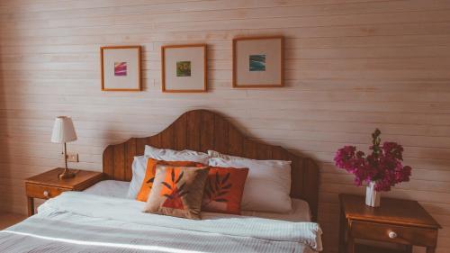a bedroom with a bed with pillows and pictures on the wall at TurkuazKöy in Finike