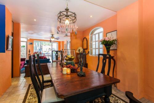 a dining room with a wooden table and a chandelier at Garlands Del Rio Riverside Boutique Hotel in Puerto Vallarta