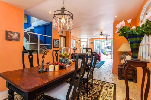 a dining room with orange walls and a wooden table at Garlands Del Rio Riverside Boutique Hotel in Puerto Vallarta