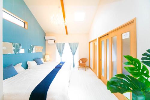 a bedroom with a large bed with a blue wall at Awaji Seaside Resort Kuruma in Awaji