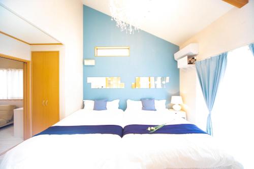 a bedroom with a bed with a blue wall at Awaji Seaside Resort Kuruma52 in Awaji