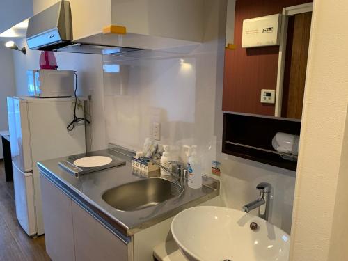 eine kleine Küche mit Spüle und Kühlschrank in der Unterkunft Clean Hotels in Higashimachi in Naha