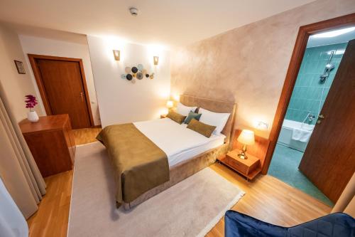 a bedroom with a bed and a bathroom with a shower at Vila Diana - Poiana Brasov with breakfast optional at hotel Simona Halep in Poiana Brasov