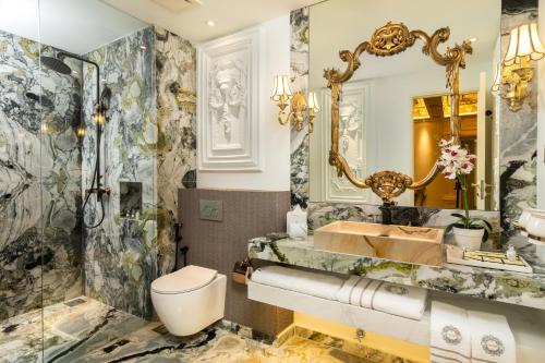 a bathroom with a toilet and a sink and a mirror at arte by Thomas Chan in Kuala Lumpur