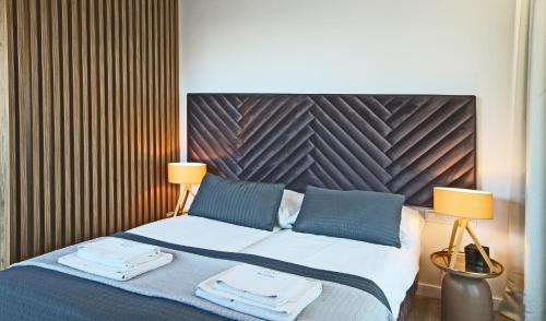 1 dormitorio con 1 cama con 2 lámparas en IRS ROYAL APARTMENTS Apartamenty IRS Yacht Park, en Gdynia