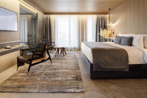 um quarto de hotel com uma cama, uma cadeira e uma secretária em Qosmo Brasov Hotel em Braşov