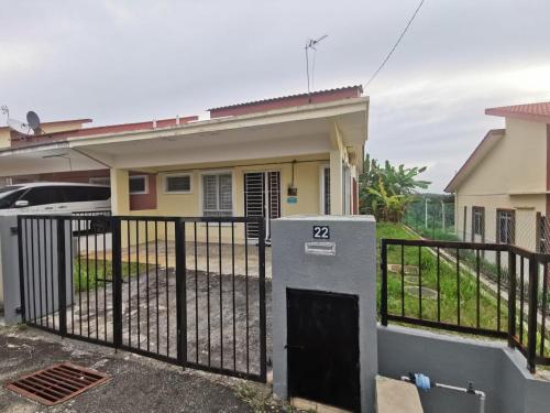 a house with a gate in front of it at AS'CATTLEYA HOMESTAY in Sepang
