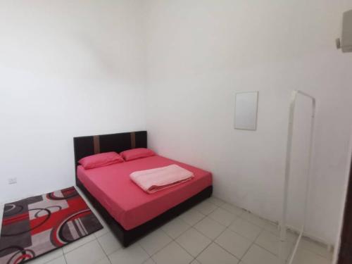 a bedroom with a red bed in a white room at AS'CATTLEYA HOMESTAY in Sepang