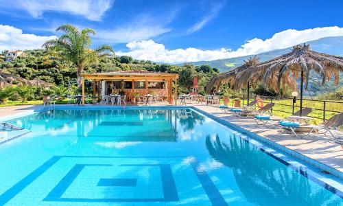 una grande piscina con sedie e gazebo di Welcome Apts a Georgioupolis