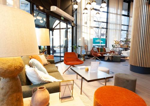 a living room with a couch and a table at Kyriad Prestige Hotel Clermont-Ferrand in Clermont-Ferrand