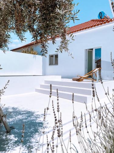 a white house with stairs and a window at Casa do Povo (casa com piscina no centro de Alcácer) in Alcácer do Sal