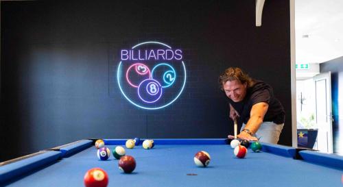 een man die pool speelt in een pooltafel bij TopParken – Recreatiepark het Esmeer in Aalst