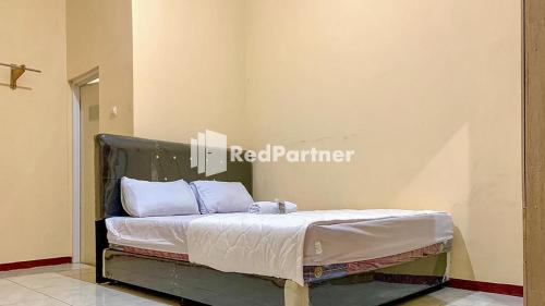 a bed with white sheets and pillows in a room at PSM Syariah Guest House RedPartner in Raab