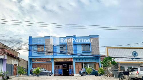 un edificio azul con un letrero de restaurante en él en PSM Syariah Guest House RedPartner, en Raab