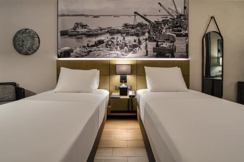 - deux lits assis l'un à côté de l'autre dans une pièce dans l'établissement K Hotel Douala, à Douala