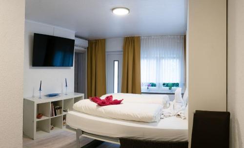 Un dormitorio con una cama blanca con un arco rojo. en Apartment-EG-09, en Darmstadt