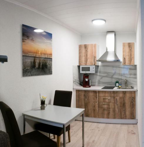 - une cuisine et une salle à manger avec une table et un évier dans l'établissement Apartment-EG-09, à Darmstadt