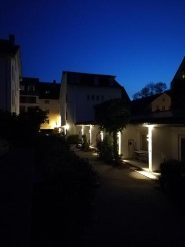eine Gruppe von Gebäuden mit Lichtern in der Nacht in der Unterkunft Apartment EG 09 in Darmstadt