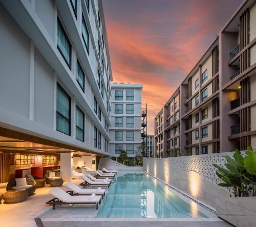 a pool in the middle of a building with lounge chairs at Travelodge Phuket Town in Phuket Town